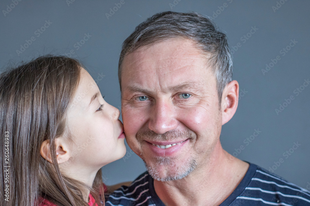 Little daughter kisses father on the cheek Little daughter kisses father on the cheek