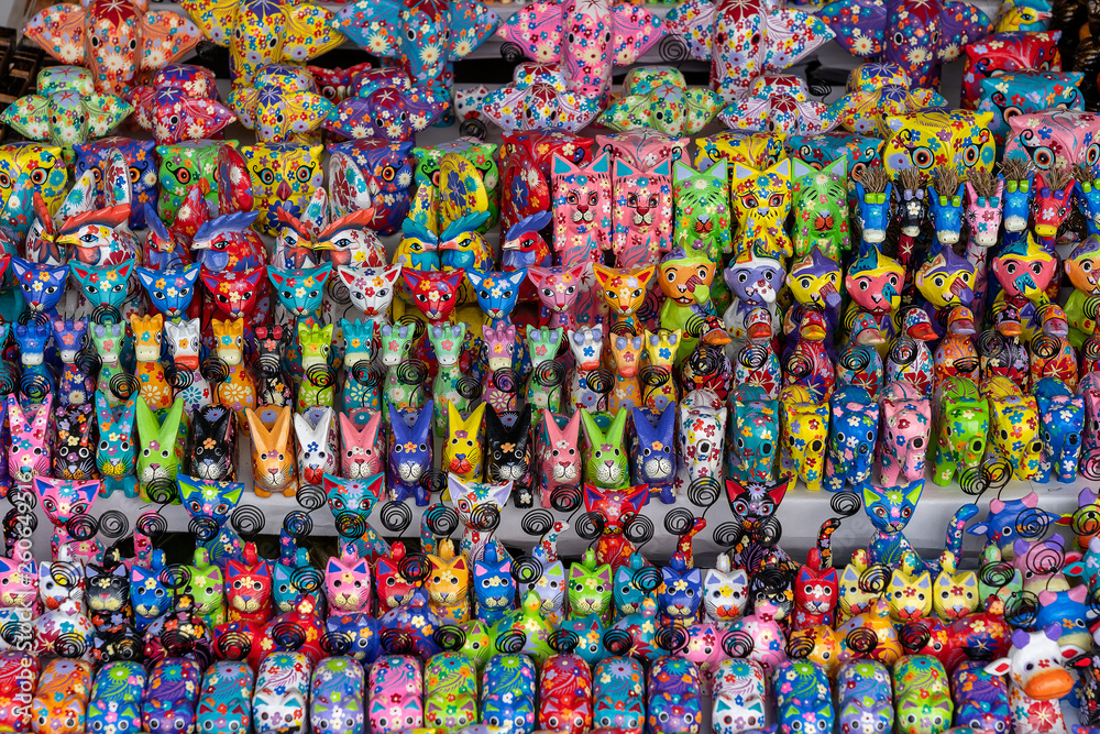Sale of souvenirs - funny handmade wooden animals in street market. Bright colorful children toys and decoration for interior. Ubud, Bali island, Indonesia. Closeup