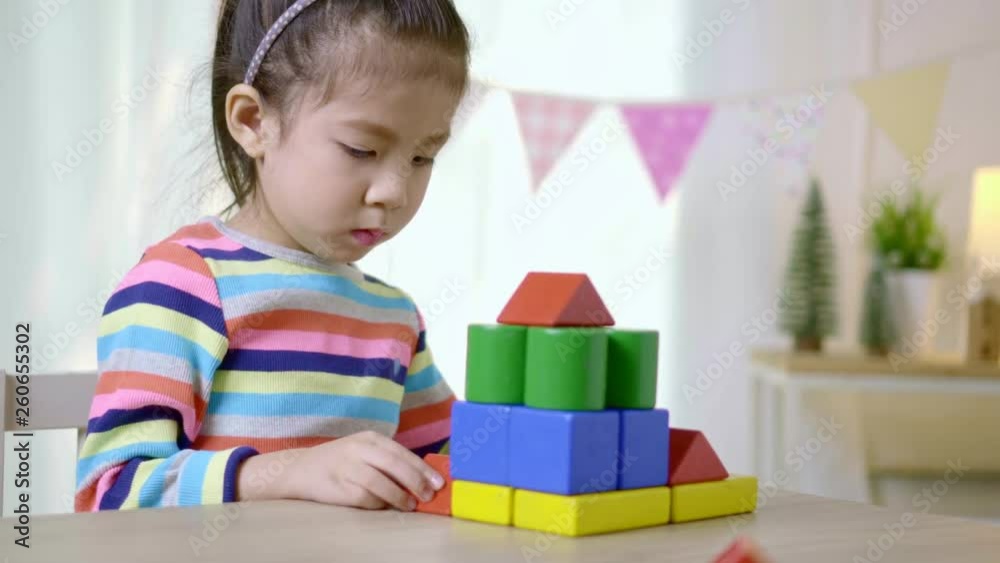 Close up shot asian little girl playing wooden games on the wooden table at home, Educational concept for school