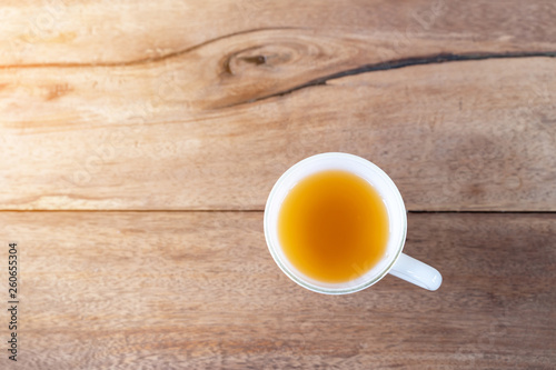 Hot tea in a cup on wooden table background with copy space