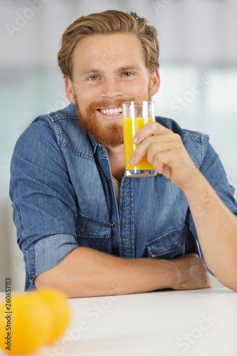 smiling young man drinking orange juice