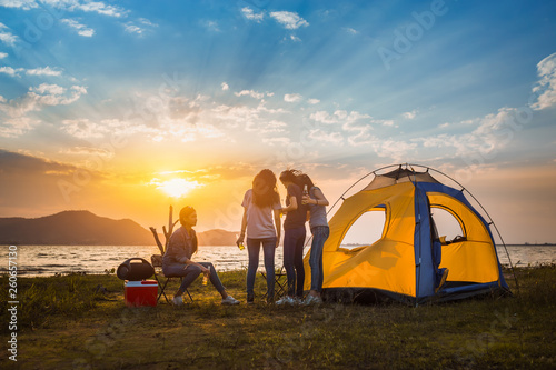 Group of asian women party with drink bottles enjoy travel camping,trekking in vacation time at sunset.
