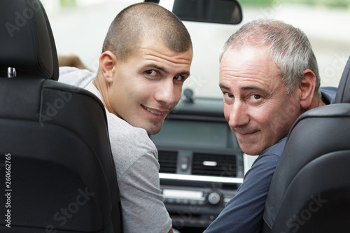 confident young salesman and customer in car