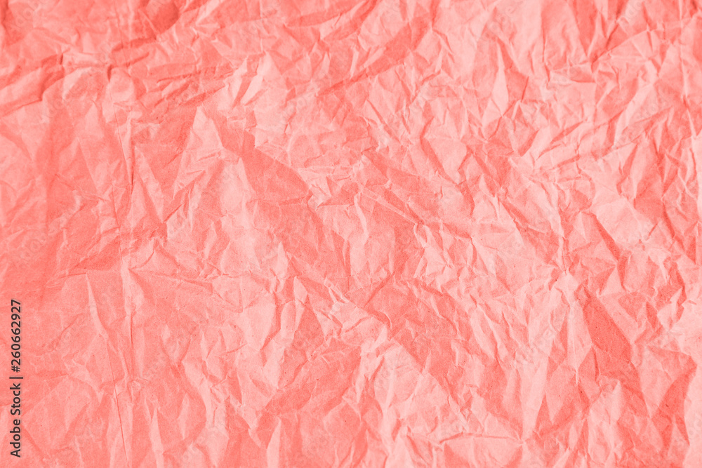 Wrinkled paper texture background in trendy coral color.
