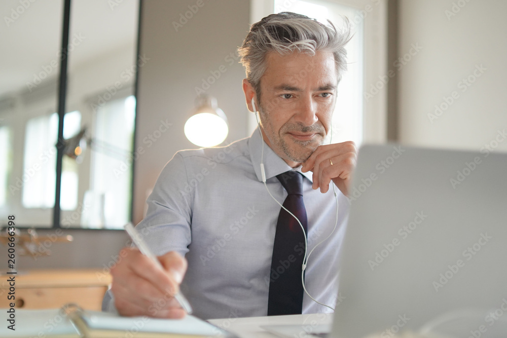 © goodluz - Businessman on video call in contemporary office © goodluz - Businessman on video call in contemporary office