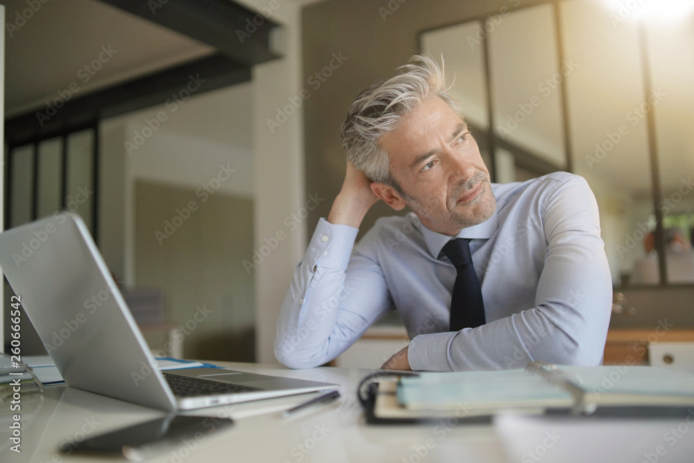 Handsome businessman in office taking a break Handsome businessman in office taking a break