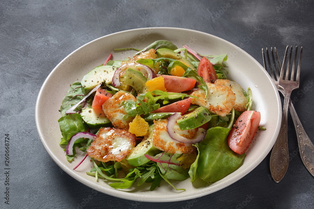Middle Eastern grilled halloumi cheese salad with avocado, oranges, cherry tomatoes, red onion, arugula beet leaves. Middle Eastern grilled halloumi cheese salad with avocado, oranges, cherry tomatoes, red onion, arugula beet leaves.