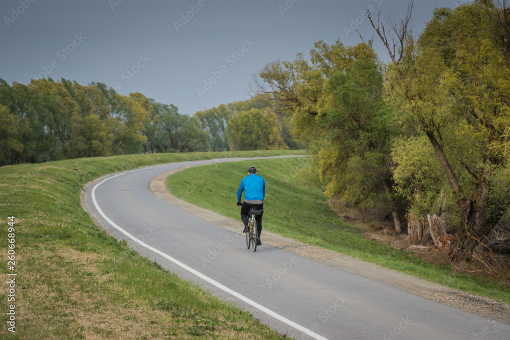 Obraz premium Guy on bicycle exercising on bike rout, rural background