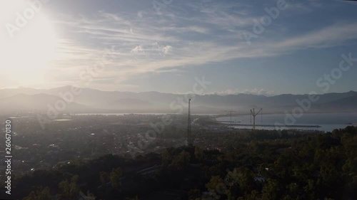 Aerial of a pretty village in Sardinia, Italy. Sunrise on the coast, mountains in the background photo