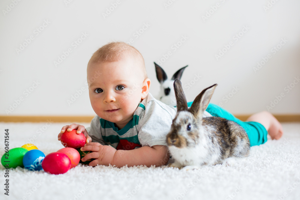 Little toddler child, baby boy, playing with bunnies and easter eggs at home Little toddler child, baby boy, playing with bunnies and easter eggs at home