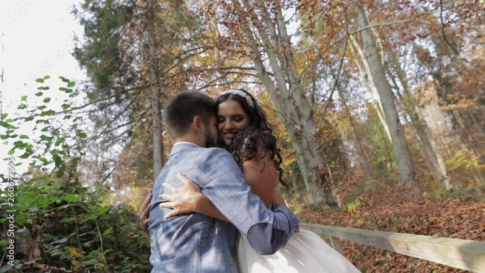 Groom with bride near mountain hills in the forest. Couple. Making a kiss Groom with bride near mountain hills in the forest. Couple. Making a kiss
