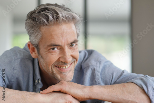 Portrait of handsome mature man looking at camera in contemporary home