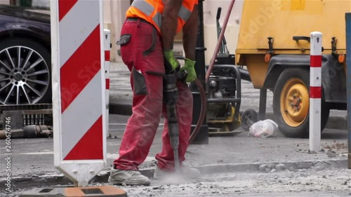 Road repairing works with jackhammer. Man with  jackhammer.