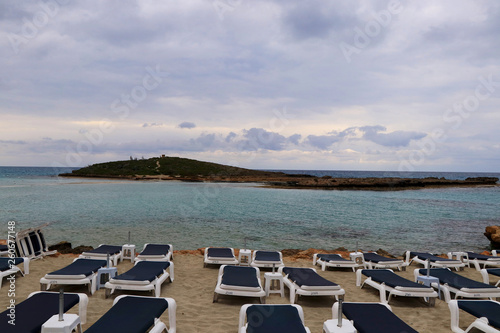 Beautiful sand beach in Ayia napa, Cyprus. Beach at dawn. Sunrise over a small hill in sea and beach. Summertime. Dawn with clouds. Vacation. Relaxing on the beach. Nissi beach © Fauren