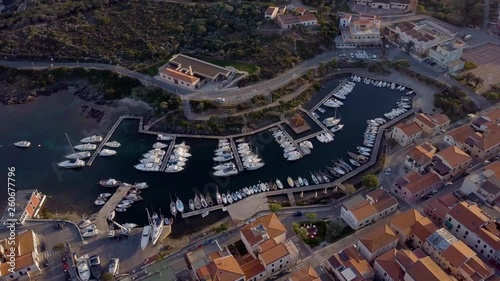 Aerial of a pretty village in Sardinia, Italy. Sunrise on the coast, parking yachts, mountains in the background photo