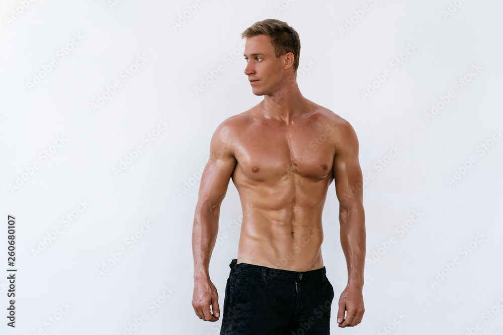 Portrait of sexy athletic man with naked torso on white background. Handsome guy with muscular body