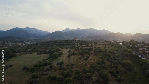 Aerial of a pretty village in Sardinia, Italy. Sunset, mountains in the background photo