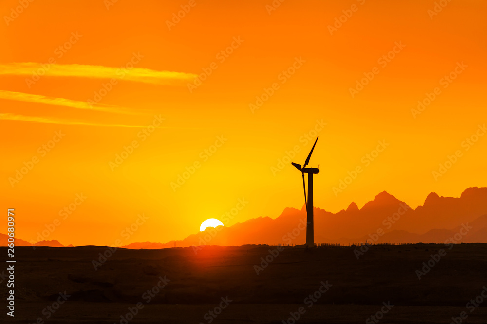 Obraz premium Big wind turbines in the desert against mountains