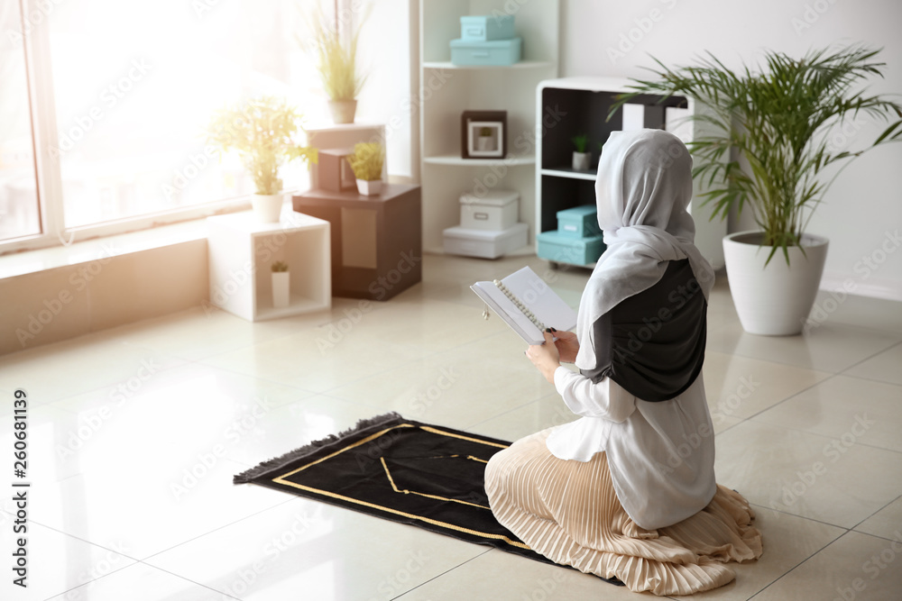 Young Muslim woman praying at home