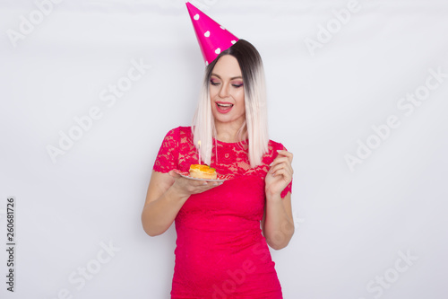 Blond in party hat holding cake