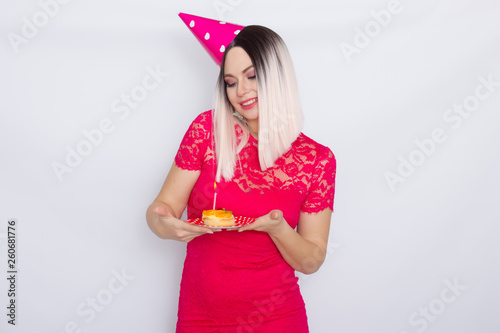 Blond in party hat holding cake