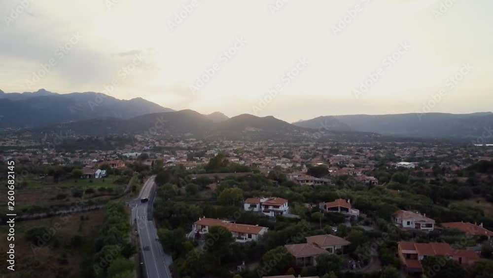 Aerial of a pretty village in Sardinia, Italy. Sunset, mountains in the background Aerial of a pretty village in Sardinia, Italy. Sunset, mountains in the background