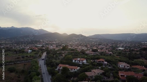 Aerial of a pretty village in Sardinia, Italy. Sunset, mountains in the background photo