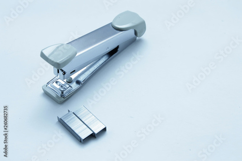 Stapler and staple on plain white background