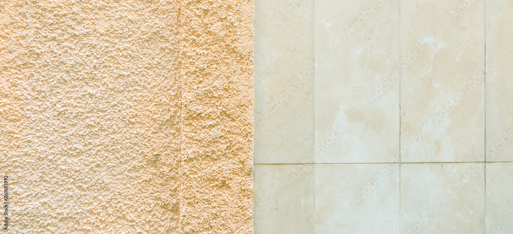 Fototapeta premium Two colored wall background consists of marble tile wall and rough textured plaster wall surface