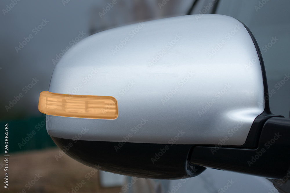 gray rearview mirror of the car with a turning signal on the background of the sky gray rearview mirror of the car with a turning signal on the background of the sky