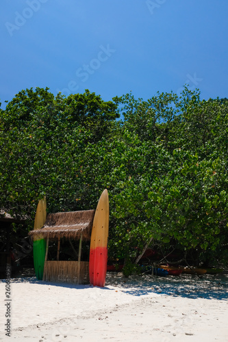 Colorful kayak canoe boat on sandy beach in tropical paradise island in sunny day in summer season. Travelling on vacation and holiday to tropical island.
