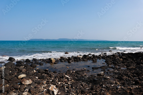 Sea wave breaks on beach rocks landscape. Sea waves crash and splash on rocks. Beach rock sea wave breaking © Aekkarach