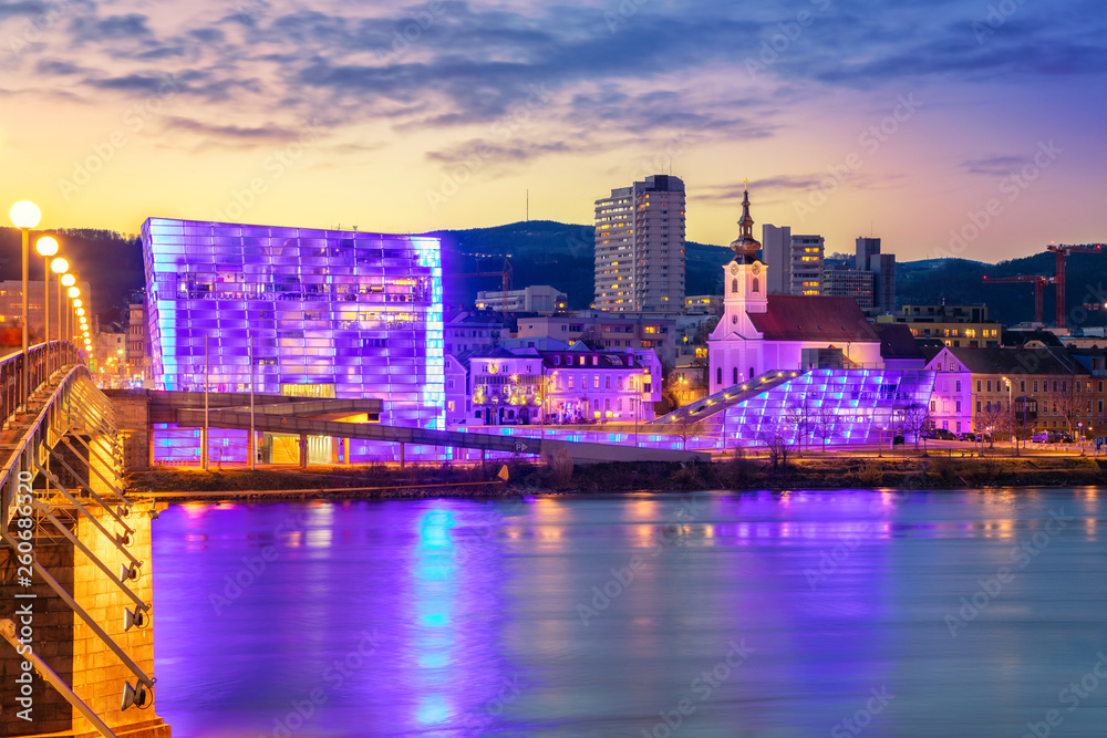 Linz, Austria. Cityscape image of riverside Linz, Austria during twilight blue hour with reflection of the city lights in Danube river.