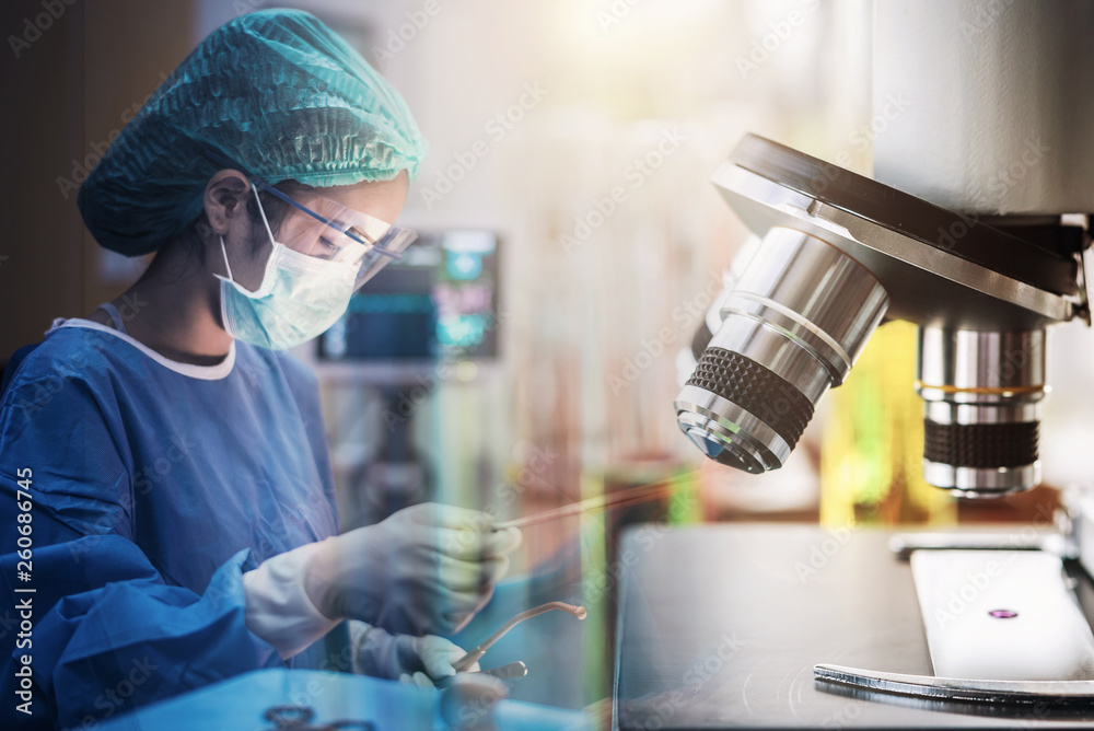 Scientist or doctor working in the operating room with microscope and glassware, medical and science research and development concept Scientist or doctor working in the operating room with microscope and glassware, medical and science research and development concept