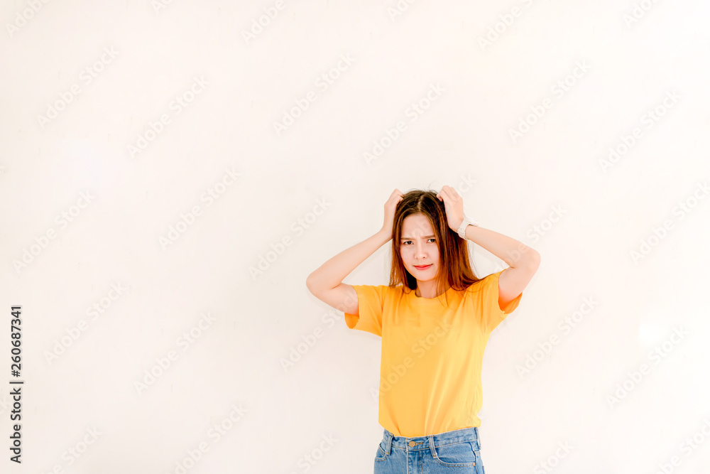 Beautiful Asian woman confident in a yellow sweater and jeans on a white background.