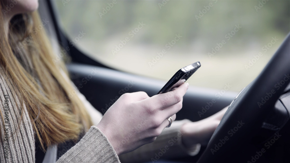 Person writing on smartphone while driving car Person writing on smartphone while driving car