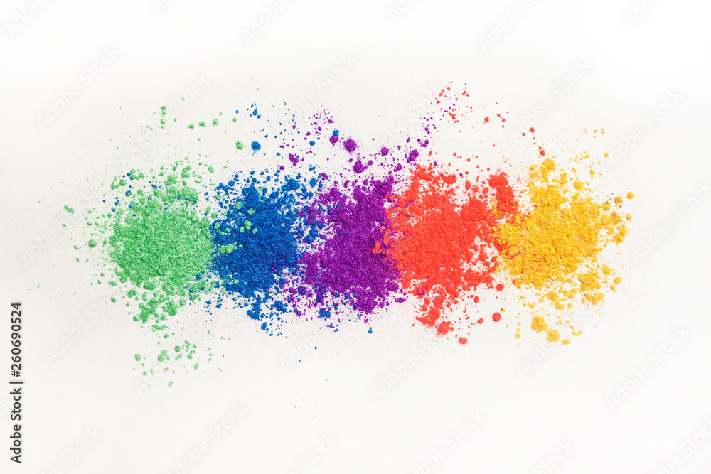 Bright eye shadows in different colors of the rainbow, scattered on a white background.