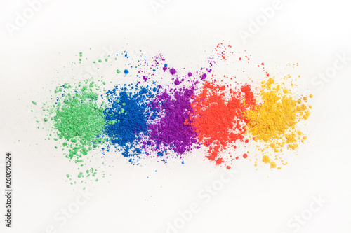 Bright eye shadows in different colors of the rainbow, scattered on a white background.