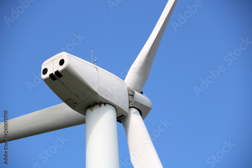 Wind turbines for electric power production on beautiful sunny summer with blue sky. Green ecological power energy generator.