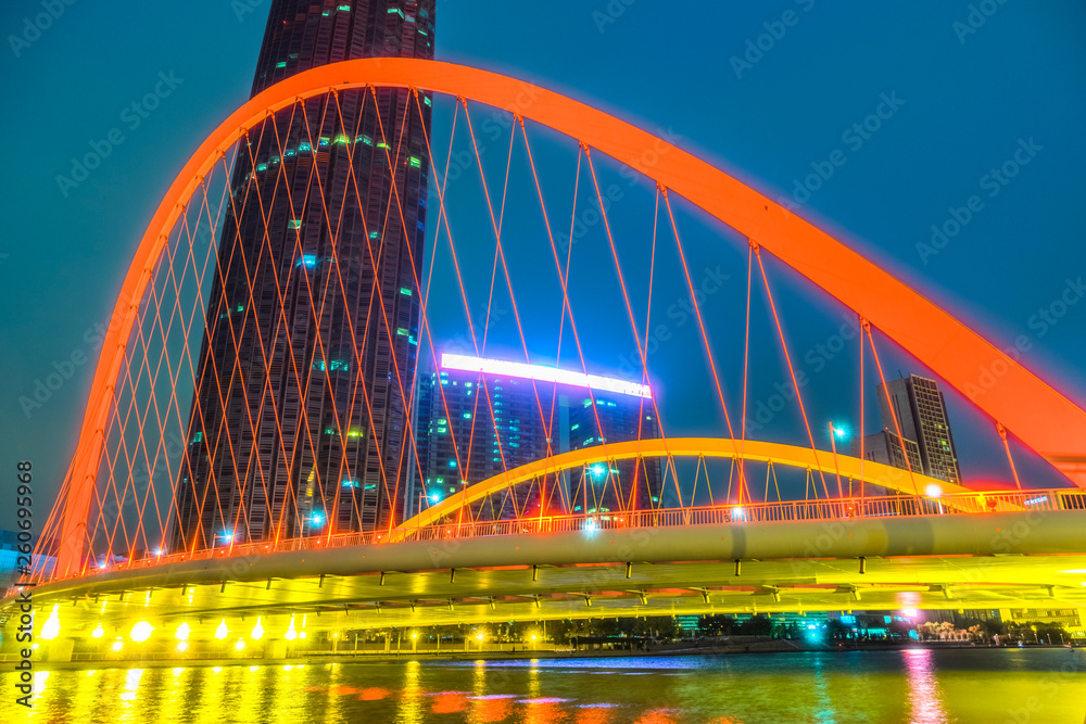 Tianjin Hai river waterfront downtown skyline with illuminated Dagu bridge,China