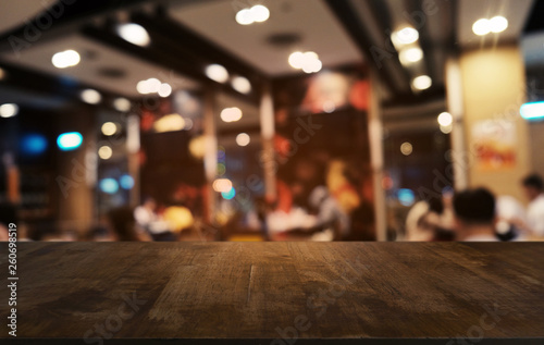 Empty dark wooden table in front of abstract blurred bokeh background of restaurant . can be used for display or montage your products.Mock up for space.