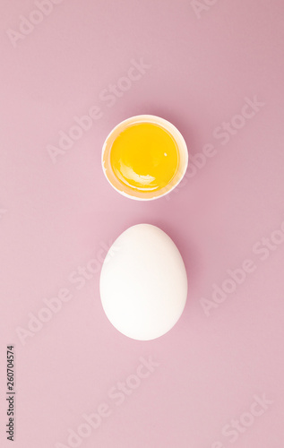 Chicken white egg with raw broken yellow yolk. Top view.  
