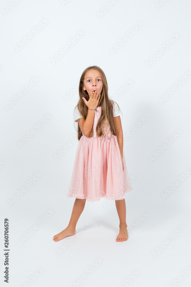 Bambina castana con capelli lunghi in abito rosa con sguardo stupito Bambina castana con capelli lunghi in abito rosa con sguardo stupito