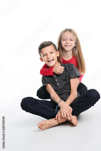 portrait of two young kids boy and girl sibling in studio shot on white background