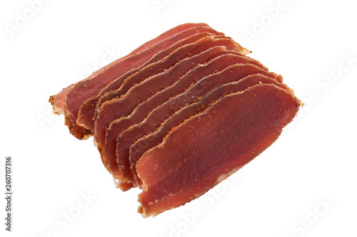 Basturma, dried tenderloin of beef meat, thinly sliced, on a white background.
