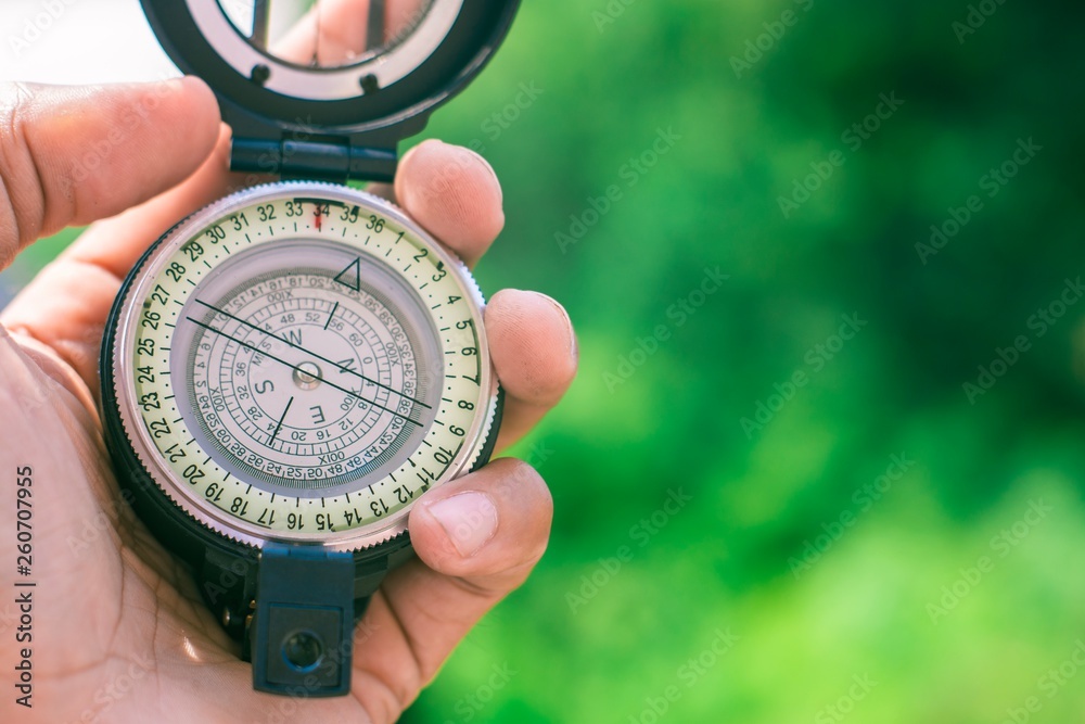 holding compass on blurred background. Using wallpaper or background travel or navigator image.