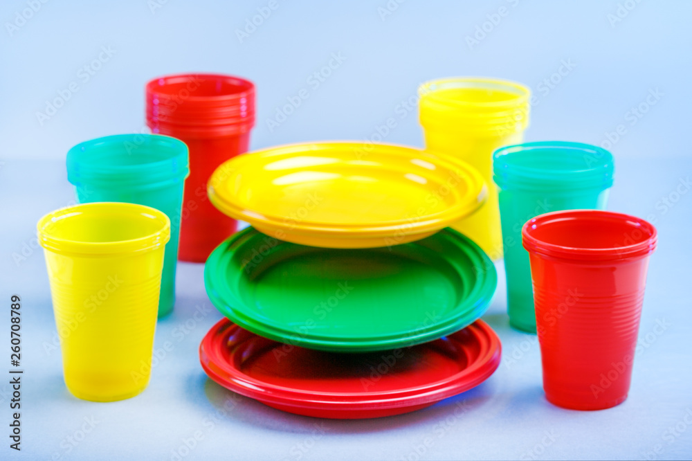Colorful plastic dishes on blue background with copy space. Colorful plastic dishes on blue background with copy space.
