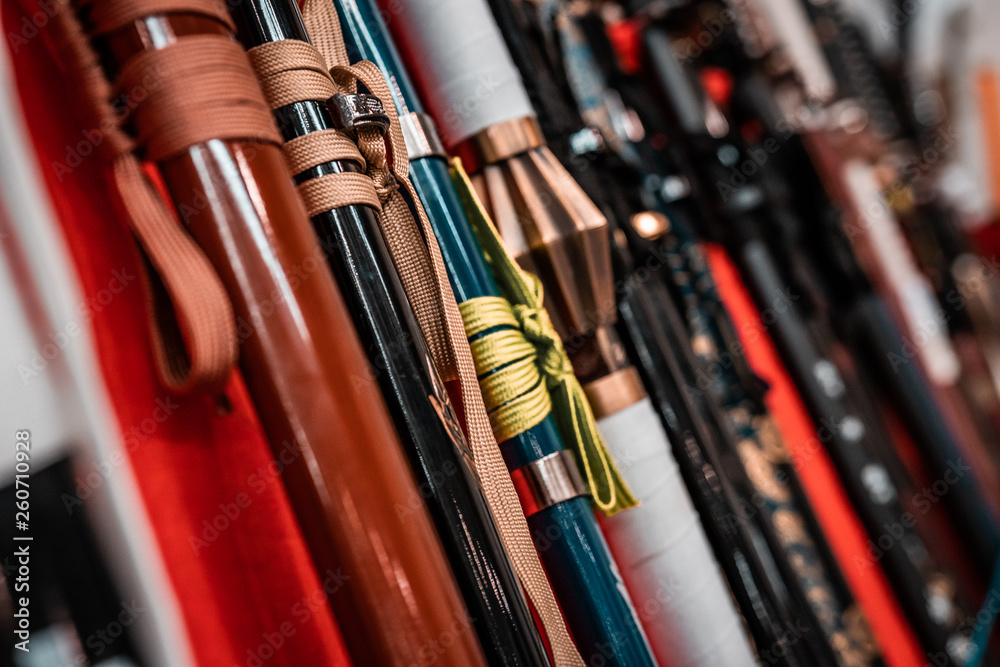 Oriental martial arts weapons, samurai katanas ready for fighting. Hand made swords, string hilt, warm colors. Ninja concept, assassin's kit. Armory rack on display. Oriental martial arts weapons, samurai katanas ready for fighting. Hand made swords, string hilt, warm colors. Ninja concept, assassin's kit. Armory rack on display.