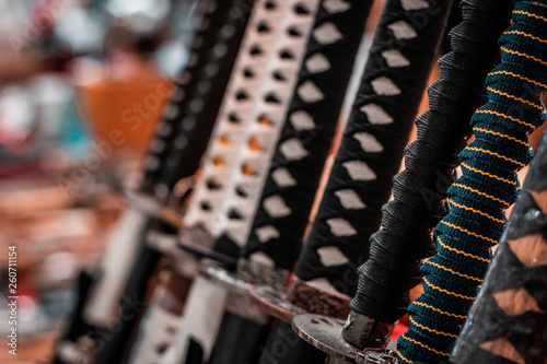 Oriental martial arts weapons, samurai katanas ready for fighting. Hand made swords, string hilt, warm colors. Ninja concept, assassin's kit. Armory rack on display.