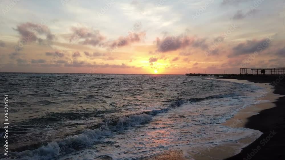 Amazing twilight at sunset on the beach in the Roman coast of Ostia Lido, with waves breaking on the shore and in the sky beautiful colored clouds Amazing twilight at sunset on the beach in the Roman coast of Ostia Lido, with waves breaking on the shore and in the sky beautiful colored clouds